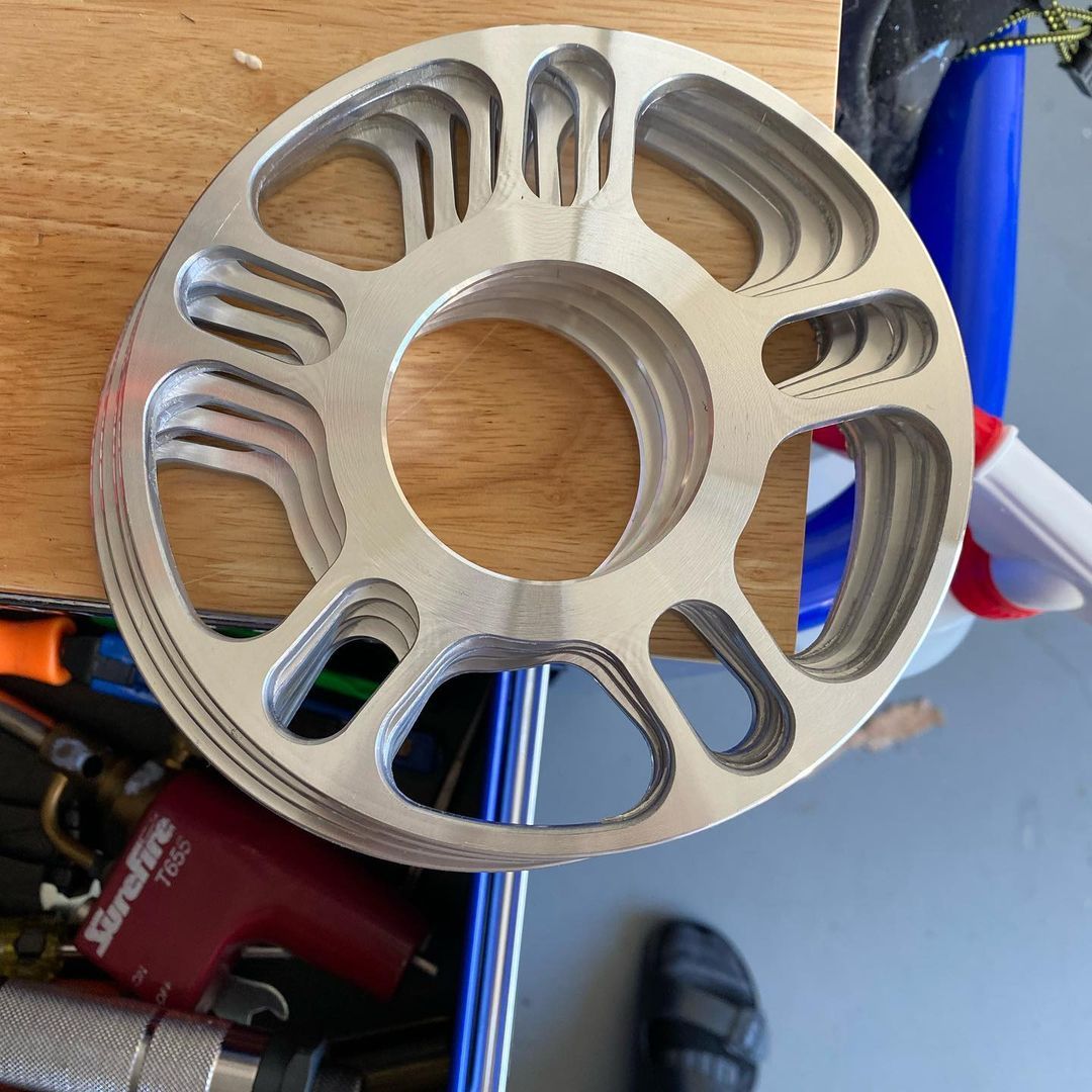 Montaż dystansu do kół krok po kroku Ręce mechanika montujące dystans aluminiowy między piastą a kołem